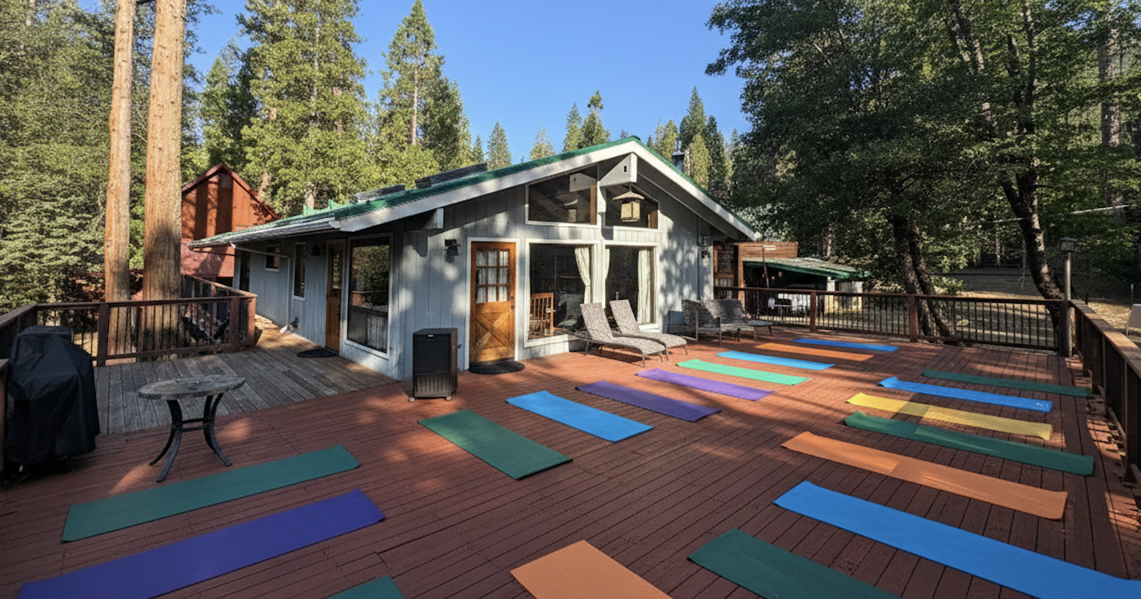 Yoga retreat setup on cabin deck with forest backdrop